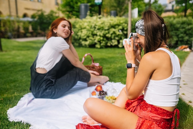 Una joven guapa morena toma una foto de su novia usando la cámara