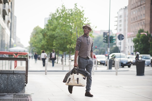 Joven guapo afro negro caminando en la calle de la ciudad