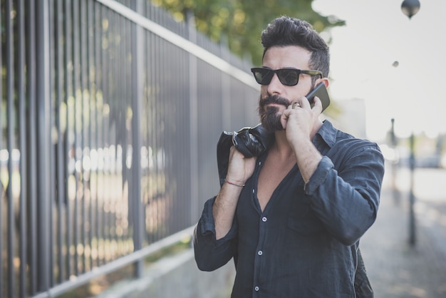 joven guapo atractivo modelo barbudo hombre con smartphone