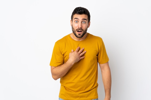 Joven guapo con barba aislado en la pared blanca apuntando a uno mismo