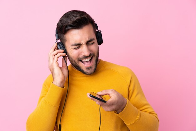 Joven guapo con barba escuchando música