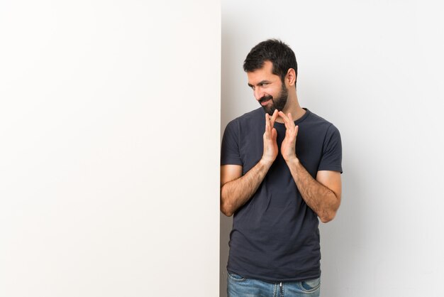 Joven guapo con barba intrigando algo