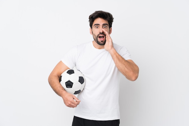 Joven guapo con barba sobre pared blanca aislada gritando con la boca abierta