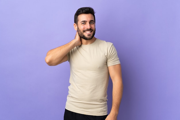 Joven guapo con barba sobre la pared riendo