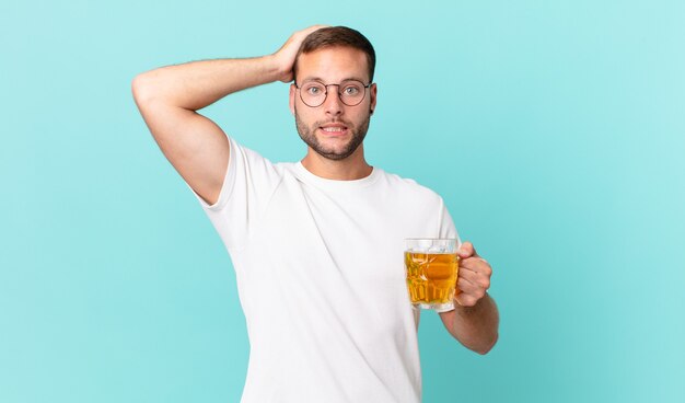 joven guapo bebiendo una pinta de cerveza