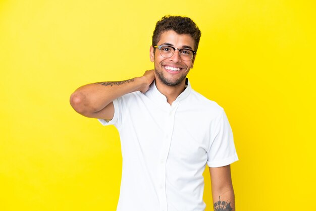 Joven guapo brasileño aislado sobre fondo amarillo riendo