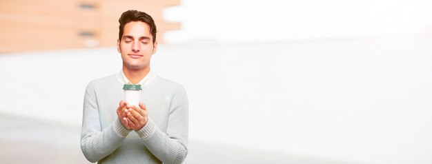 Joven guapo bronceado con un café para llevar