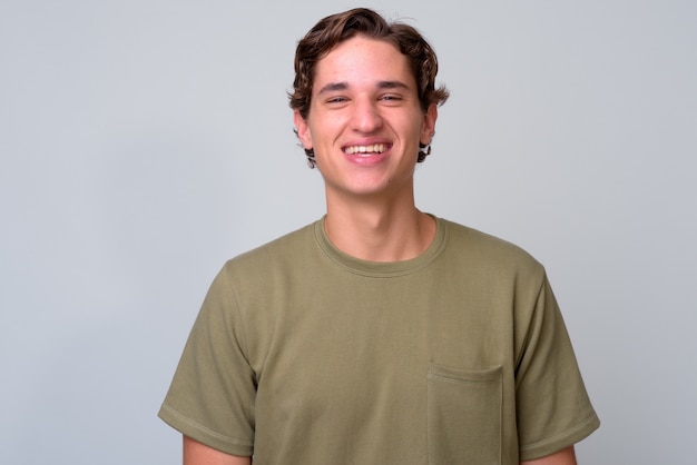 Foto joven guapo con cabello ondulado vistiendo camisa verde