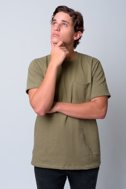 Joven guapo con cabello ondulado vistiendo camisa verde