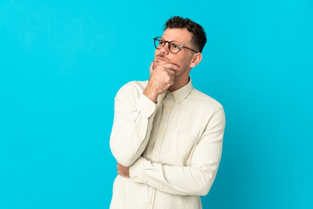 Joven guapo caucásico en azul con dudas