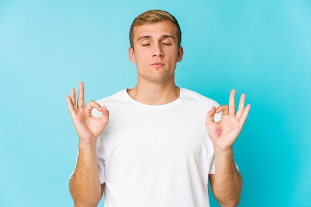 Joven guapo caucásico se relaja después de un duro día de trabajo, ella está realizando yoga.