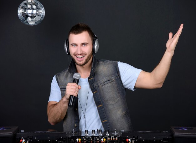 Joven guapo deejay tocando música de club.