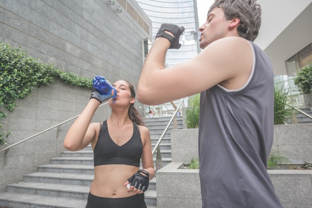 joven guapo deportiva hombre y mujer bebiendo