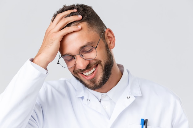 Joven guapo doctor hombre sonriendo