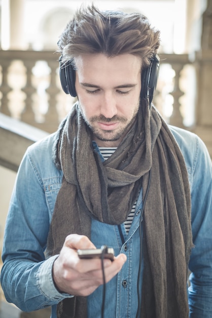 joven guapo escuchando música con auriculares