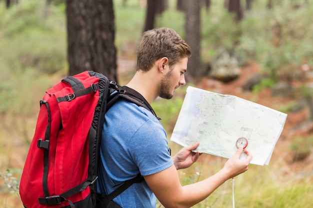 Joven guapo excursionista utilizando mapa