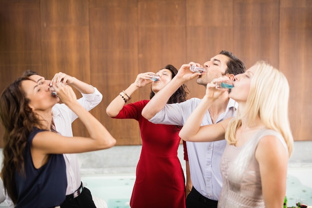 Joven y guapo grupo de amigos bebiendo tragos en la fiesta