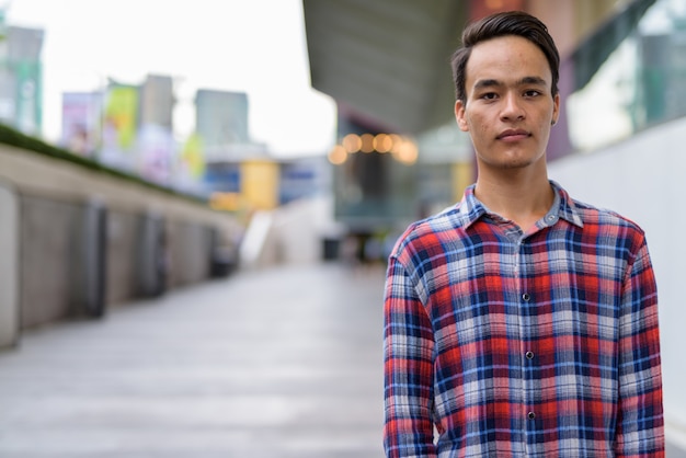 Joven guapo indio explorando la ciudad de Bangkok, Tailandia