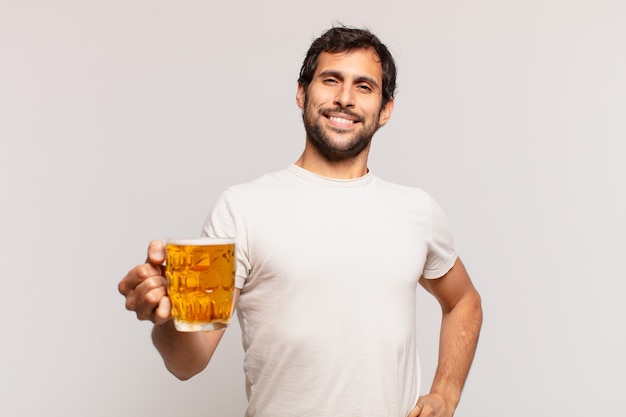 Joven guapo indio expresión feliz y sosteniendo una cerveza