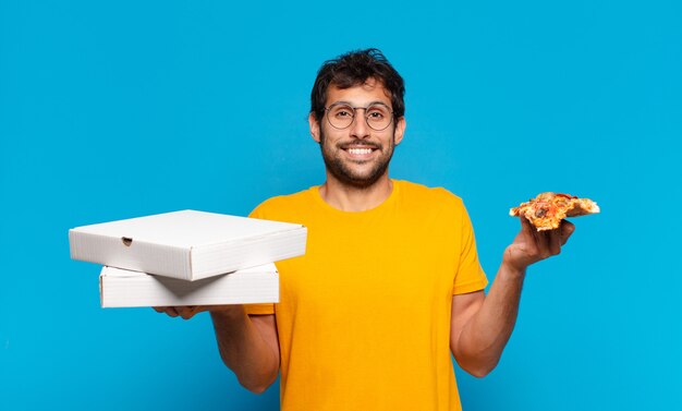 Joven guapo indio expresión feliz y sosteniendo pizzas para llevar