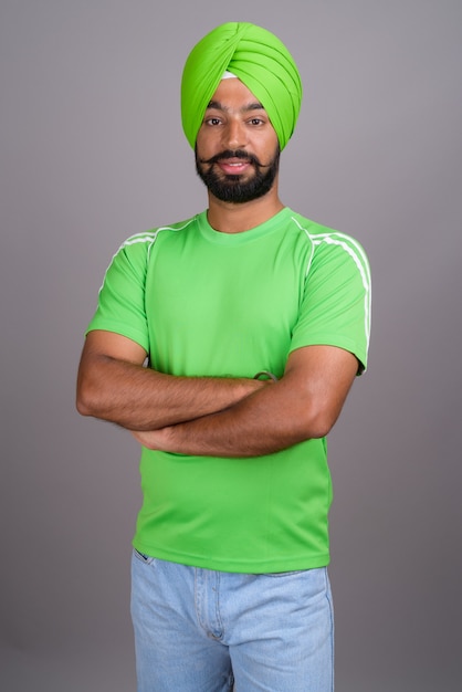 Joven guapo indio sij hombre vestido con turbante y camisa verde