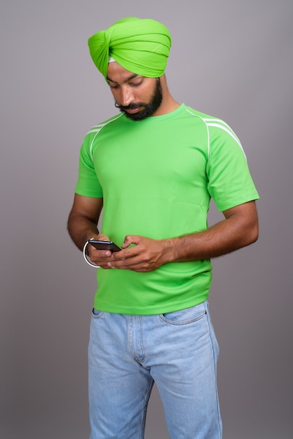 Joven guapo indio sij hombre vestido con turbante y camisa verde