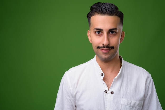 Joven guapo iraní con bigote en verde