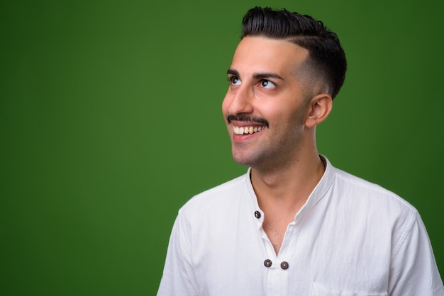 Joven guapo iraní con bigote en verde