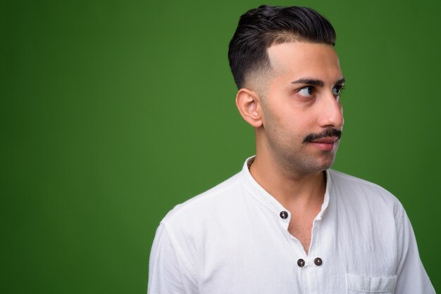 Joven guapo iraní con bigote en verde