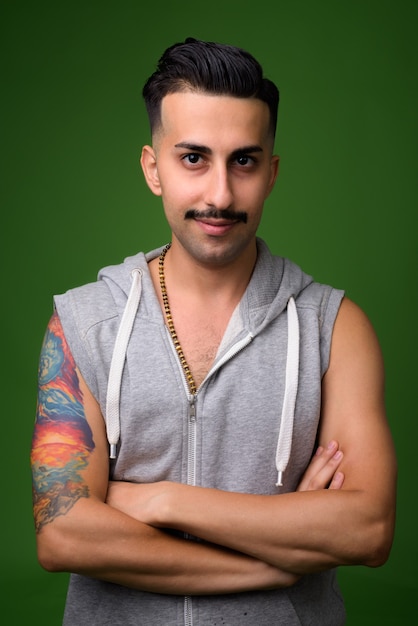 Joven guapo iraní con bigote en verde