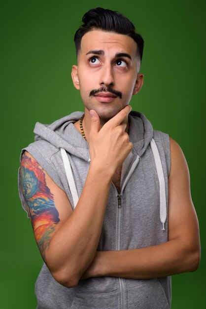 Joven guapo iraní con bigote en verde