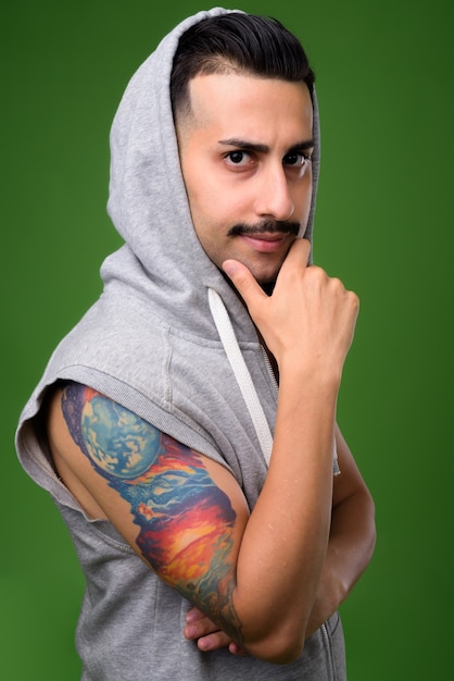 Joven guapo iraní con bigote en verde