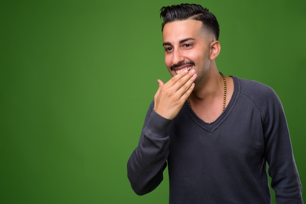 Joven guapo iraní con bigote en verde