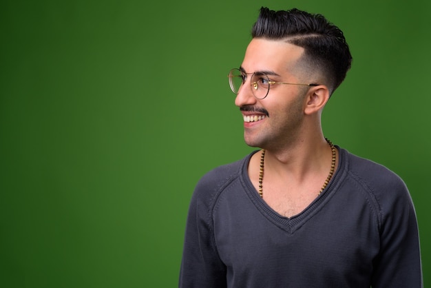 Joven guapo iraní con bigote en verde