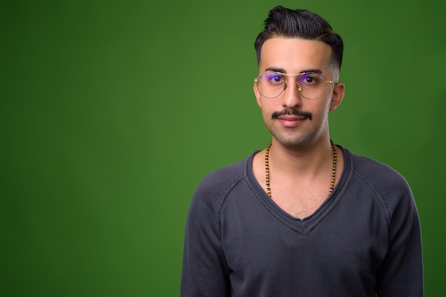 Joven guapo iraní con bigote en verde