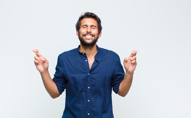 Joven guapo latino en camisa aislado