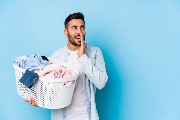 Joven guapo lavando la ropa está diciendo una noticia secreta de frenado en caliente y mirando a un lado