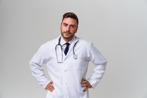 Joven guapo médico caucásico sobre fondo blanco