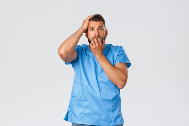 Foto joven guapo médico en uniforme azul