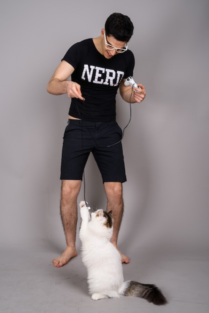 Joven guapo nerd con anteojos contra gris