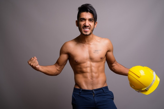 Joven guapo persa trabajador de la construcción sin camisa