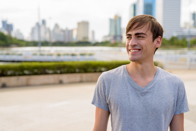 Joven guapo relajante en el parque