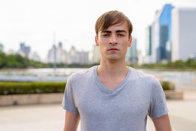 Joven guapo relajante en el parque