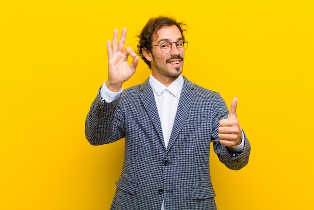 Joven guapo sintiéndose feliz, asombrado, satisfecho y sorprendido