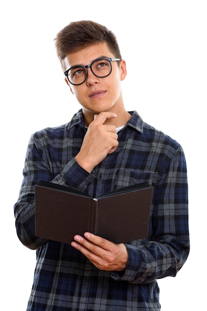 joven guapo sosteniendo libro mientras piensa