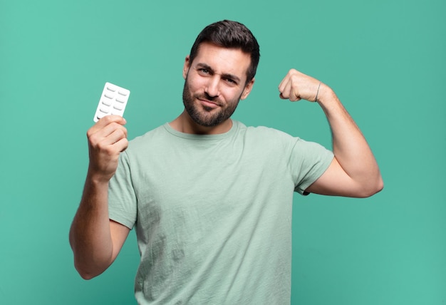 joven guapo con una tableta de pastillas. concepto de enfermedad o dolor