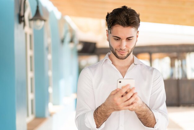 Foto joven guapo con teléfono móvil