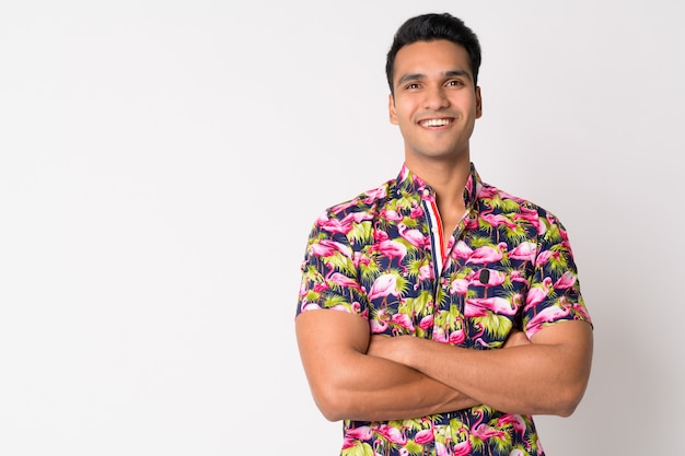 Joven guapo turista indio en camisa bohemia contra la pared blanca