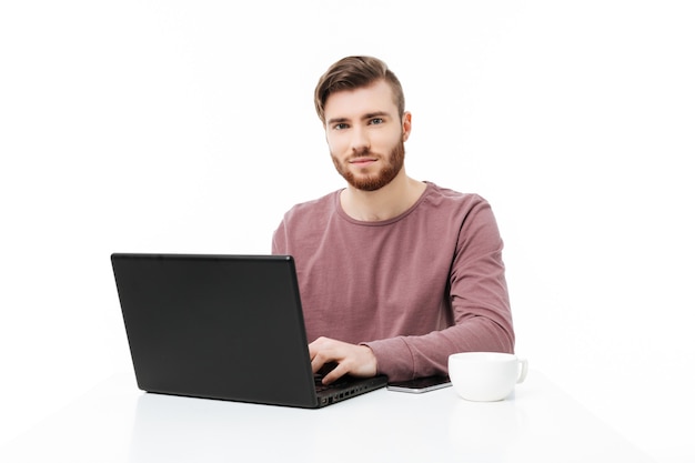 Joven guapo usando una computadora portátil