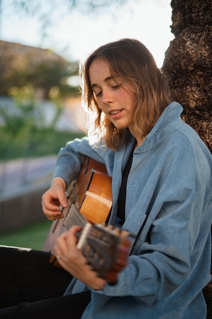 Joven guitarrista en el parque